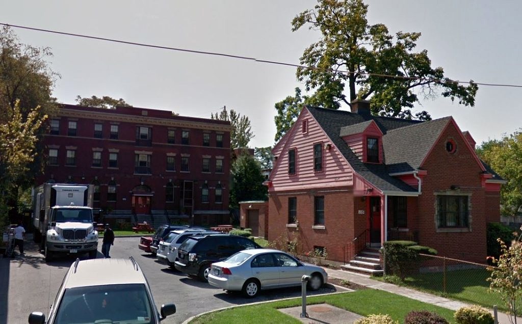 A smallish house in the foreground in front of a large brick building