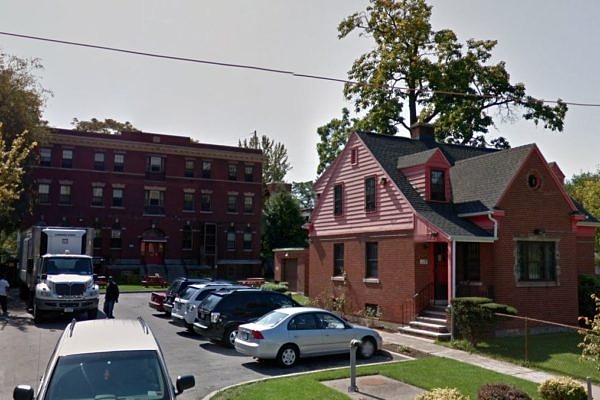 A smallish house in the foreground in front of a large brick building