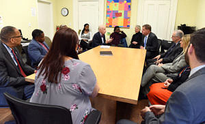 A large group of people sitting around a conference table