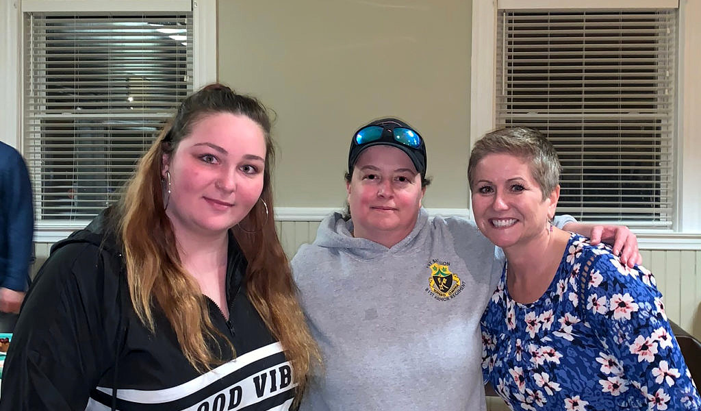 Three women standing shoulder to shoulder