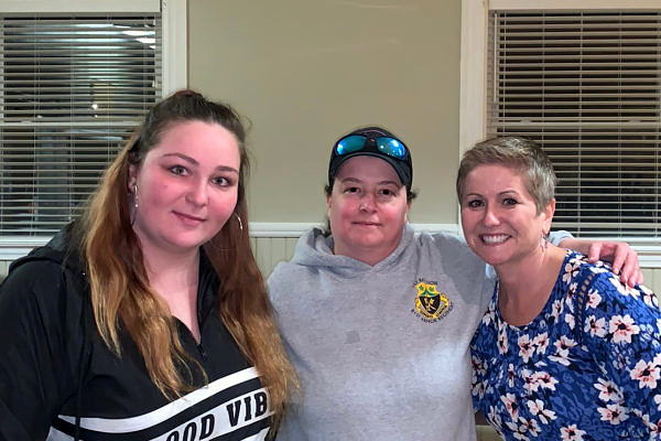 Three women standing shoulder to shoulder