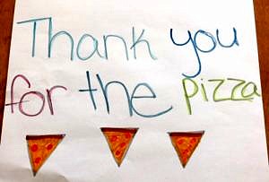 A homemade sign that says thank you for the pizza