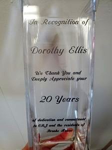 A glass vase with the inscription "In recognition of Dorothy Ellis. We thank you and deeply appreciate your 20 years of dedication and commitment to CRJ and the residents of Brooke House"