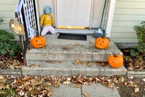 Jack o'-lanterns arranged on the front steps of a home