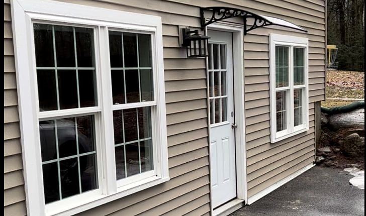 An exterior picture shows a new door with large windows on either side