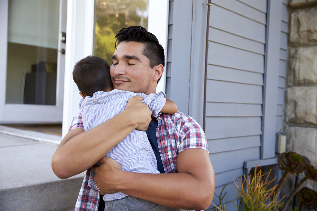 Photo of a man hugging a child